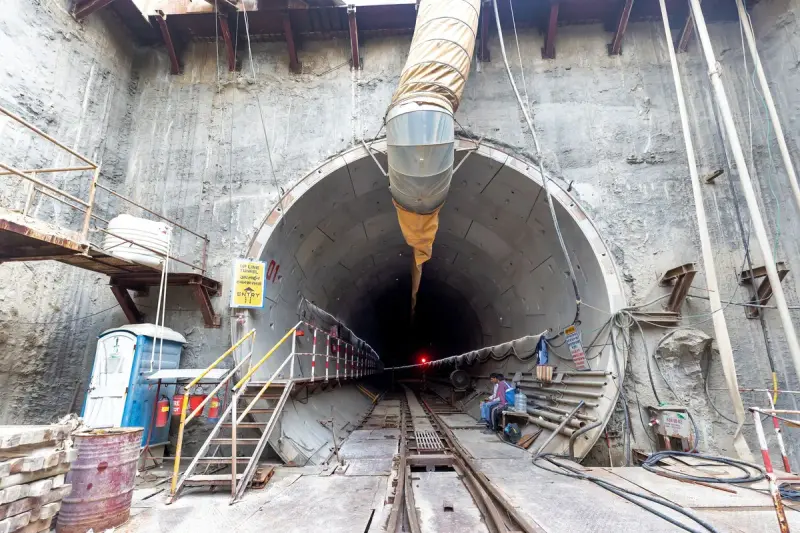 Tunnel portal with rail track, ventilation duct and work platforms at a construction site