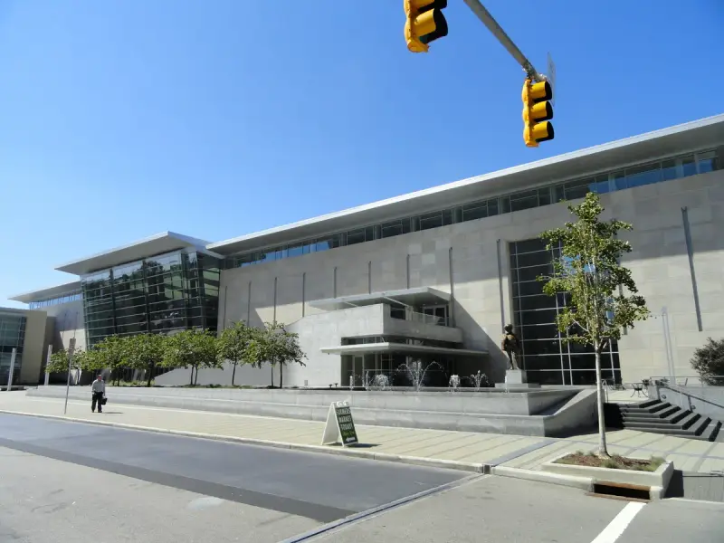 Stone and glass front of the Raleigh Convention Center on a sunny day in downtown Raleigh