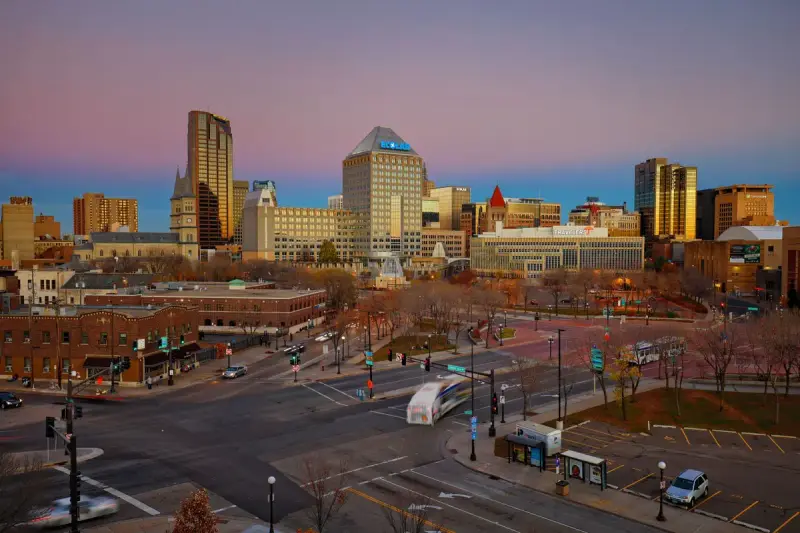 Downtown Saint Paul skyline at dusk with traffic moving through the streets below