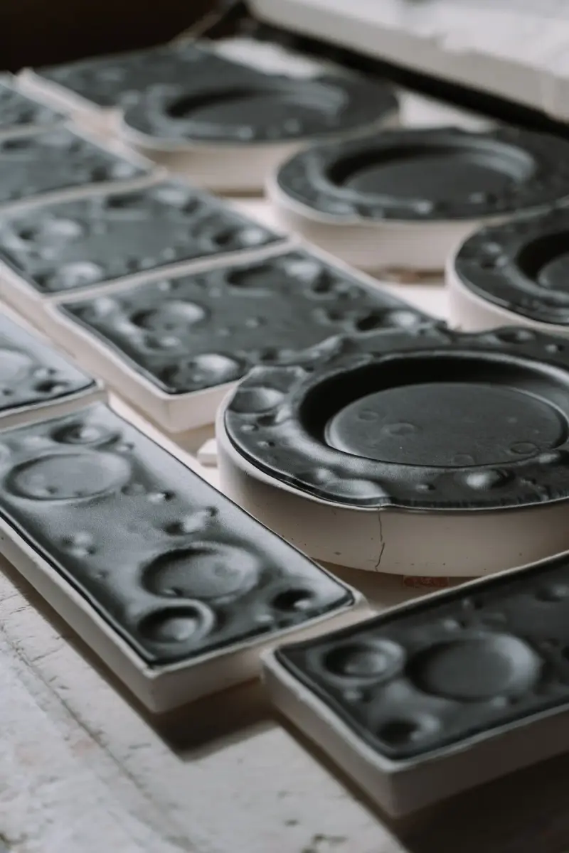 Black plastic injection molds stacked in a manufacturing workshop