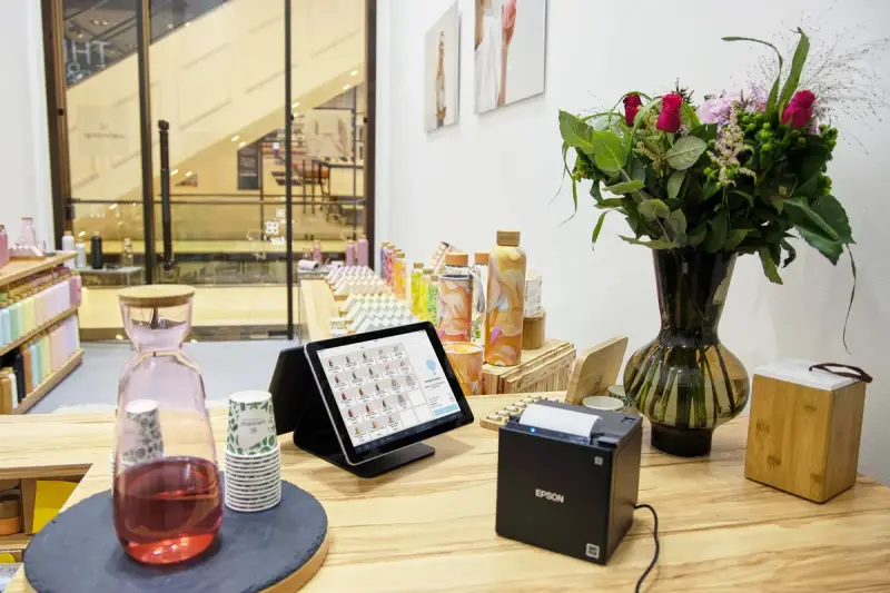 Store checkout counter with a tablet point of sale, receipt printer and flowers