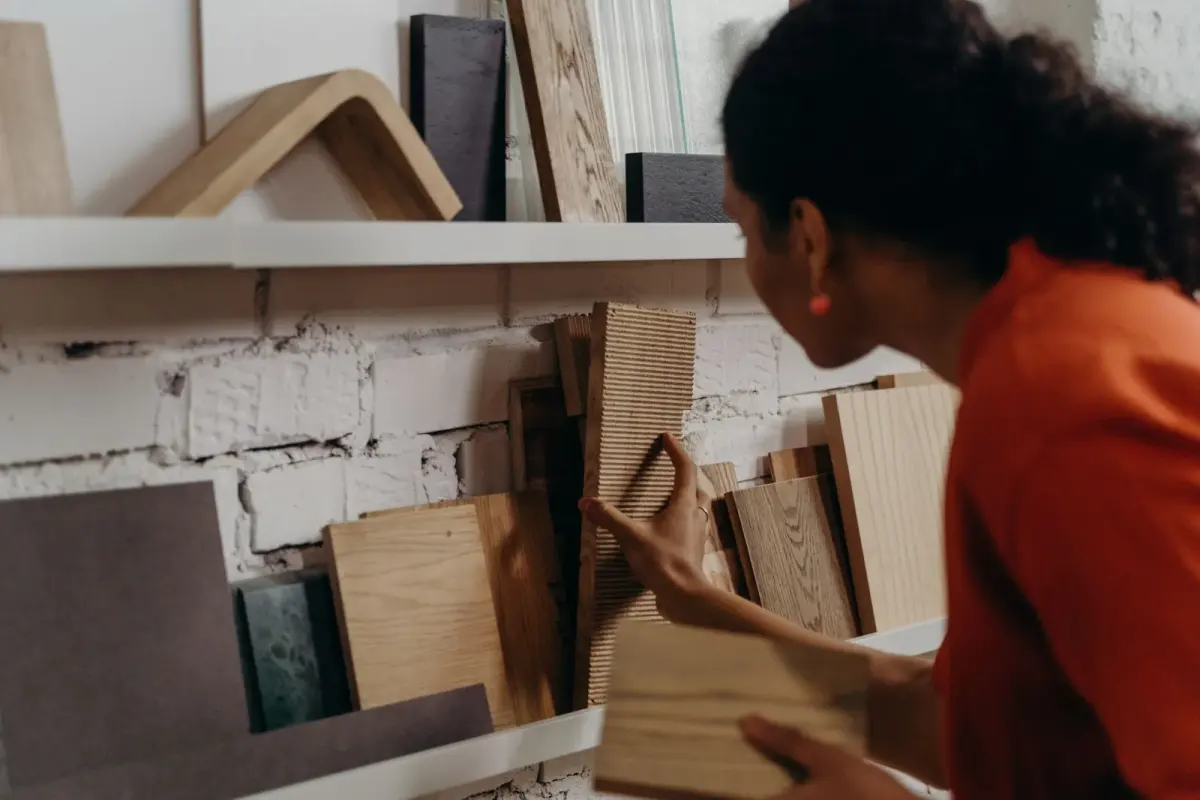 Woman comparing wood samples on a showroom display wall