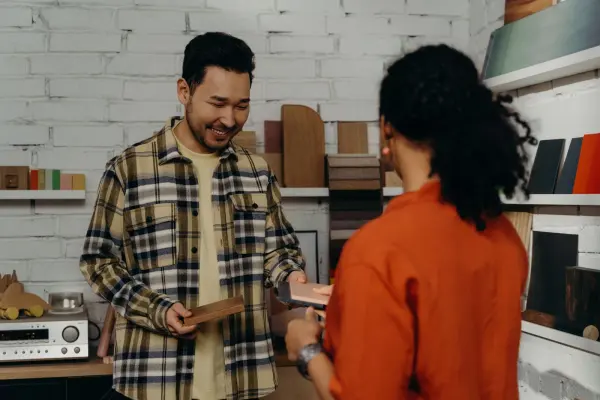 A showroom professional and female client discussing wood samples