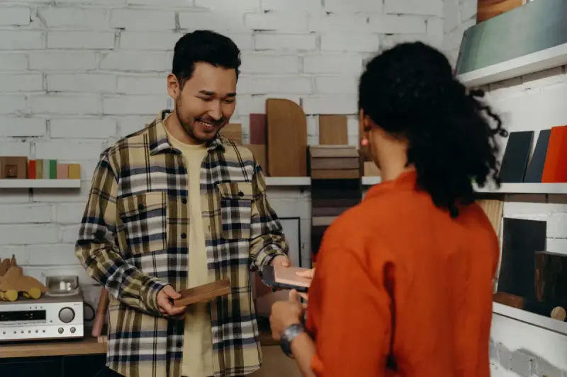 A showroom professional and female client discussing wood samples