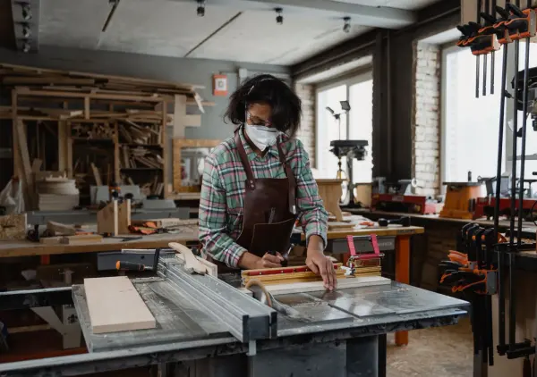 Woman working with timber and tools in a workshop
