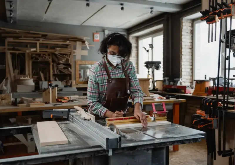 Woman working with timber and tools in a workshop