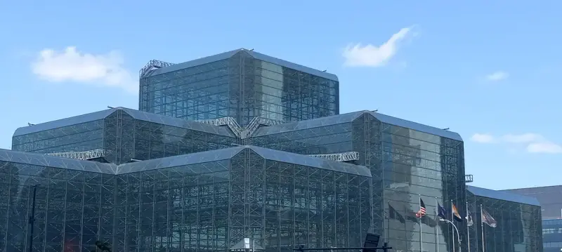 Glass and steel space frame facade of the Javits Center under a blue sky