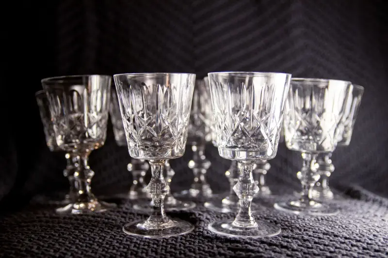 Set of cut crystal goblets on textured fabric under soft light