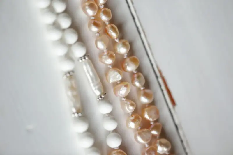 Pearl and bead necklaces laid on a white surface