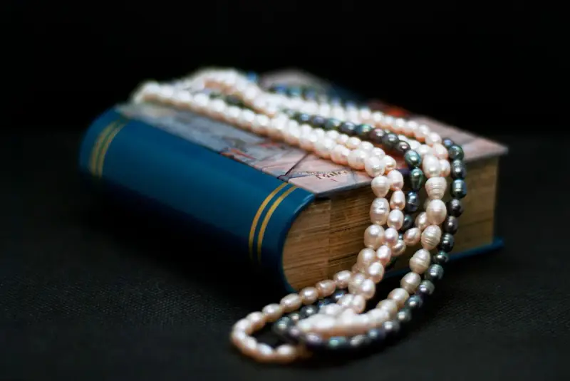 Pearl necklaces draped over a blue hardcover book