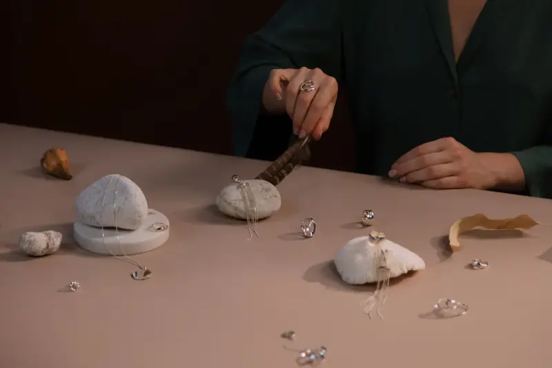 Jewelry arranged among rocks and natural textures on a table