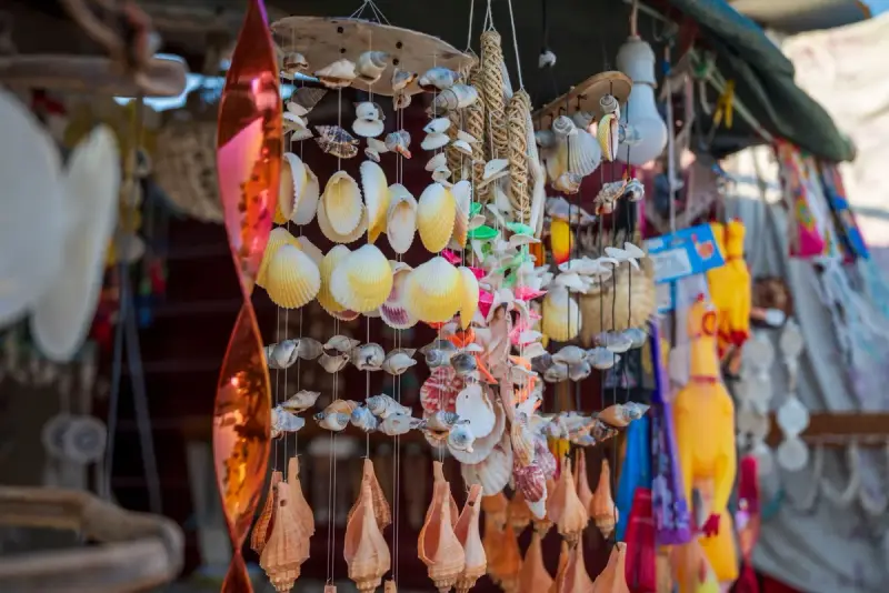 Seashell mobiles and beach-themed crafts hanging at an outdoor stall