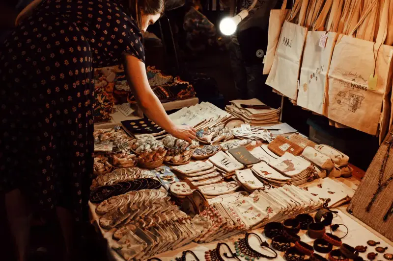Woman browsing handmade crafts and souvenirs at a market stall