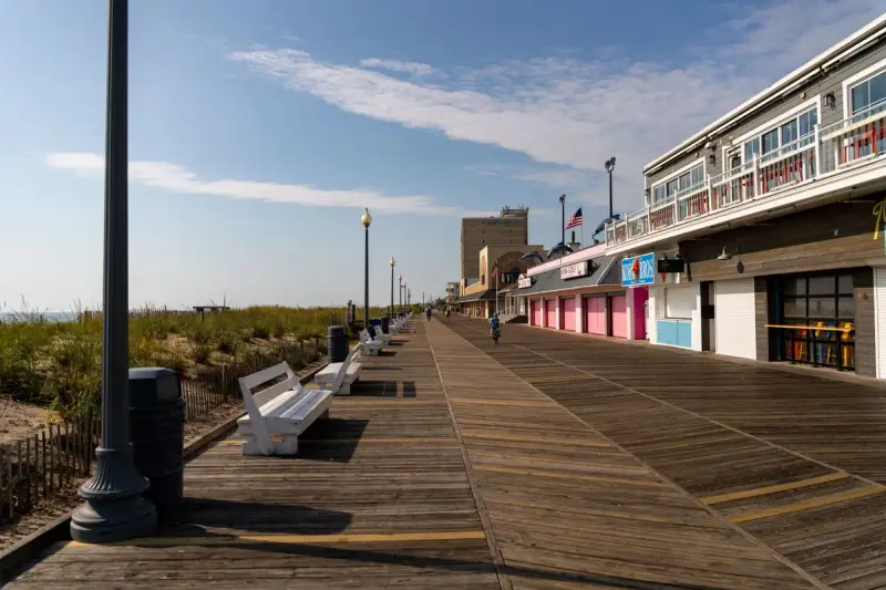 Sunny Rehoboth Beach boardwalk in Delaware lined with storefronts