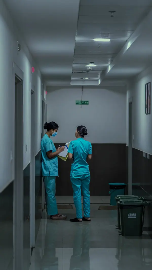 Nursing professionals discussing notes in a hospital corridor
