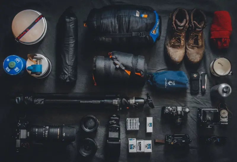 Overhead flat lay of neatly arranged camping and photography equipment