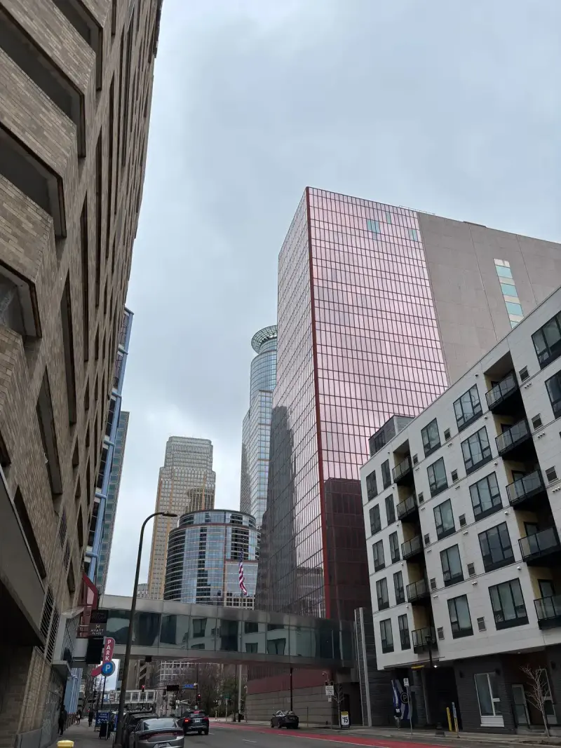 Downtown Minneapolis skyscrapers joined by enclosed skyways under a cloudy sky