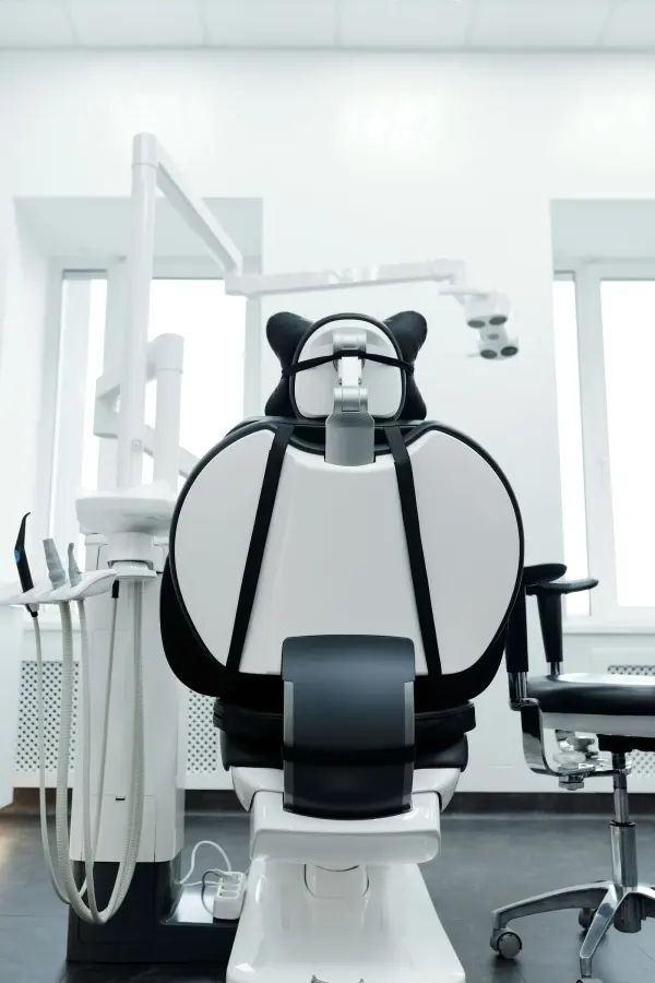 Dental treatment chair with delivery equipment and overhead examination light