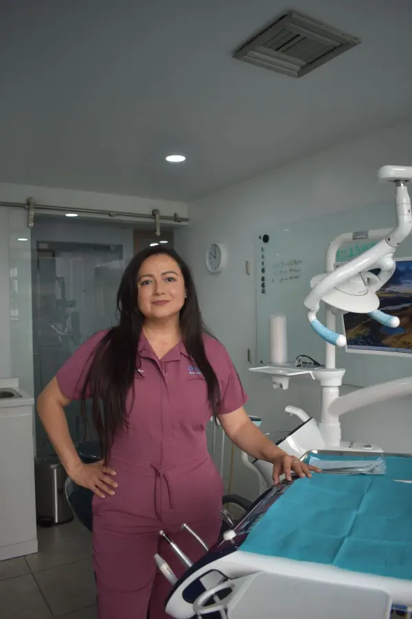 A female dental professional standing in a modern clinic setting
