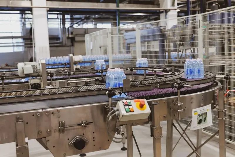 Rows of water bottles moving along an automated conveyor in a modern bottling plant