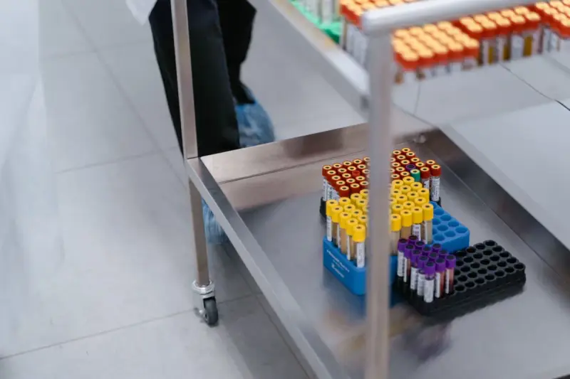 Lab trolley carrying racks of tubes with yellow, blue and purple caps