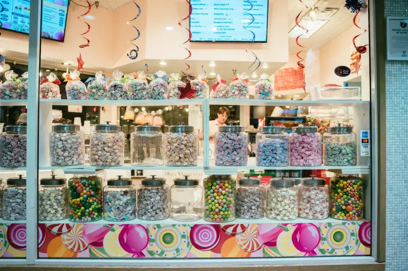 Shop window display of colorful candies in rows of glass jars