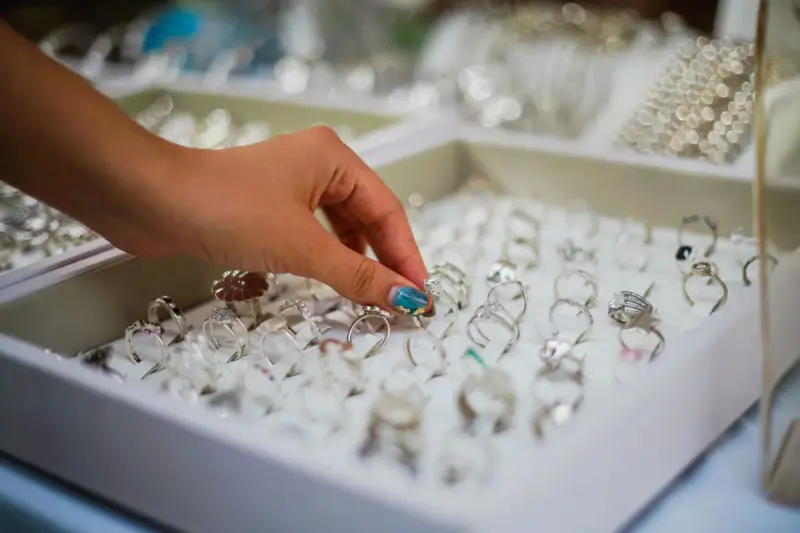 Woman's hand picking a ring from a jewelry display