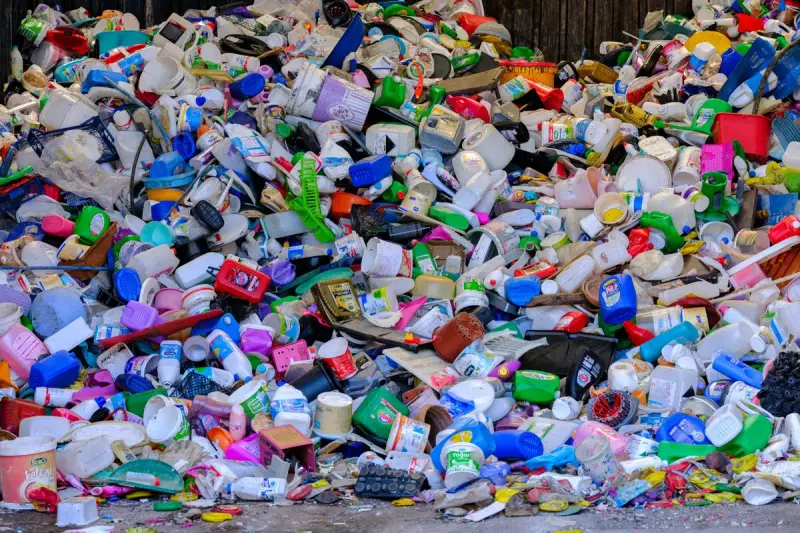 Mountain of mixed colorful plastic bottles, containers and caps at a recycling center