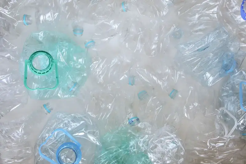 Crushed clear and pale green plastic bottles seen from above