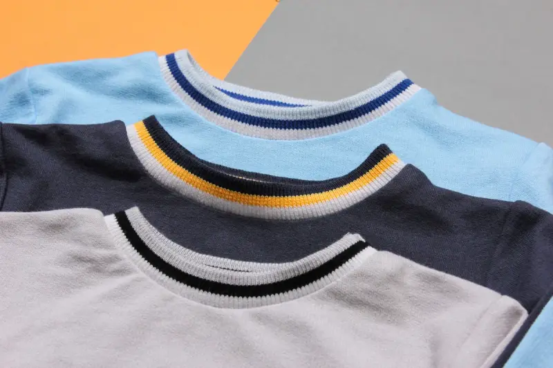 Stacked children's crewneck sweatshirts in sky blue, navy and gray with tipped collars