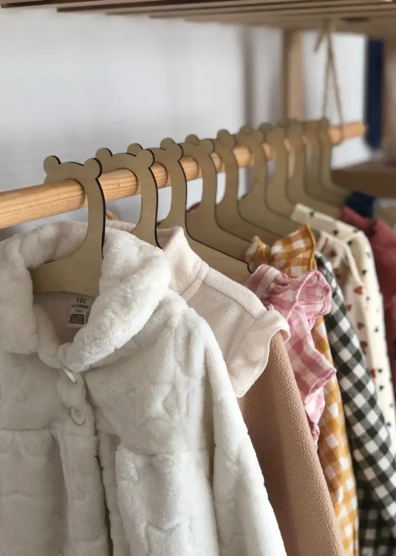 Children's jackets and shirts on bear-shaped wooden hangers