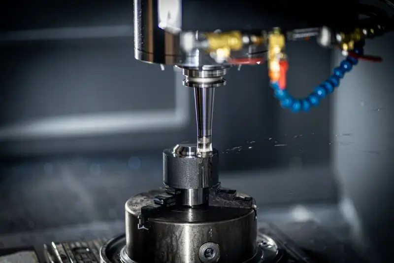 CNC machine cutting a metal part inside its enclosure in a machine shop
