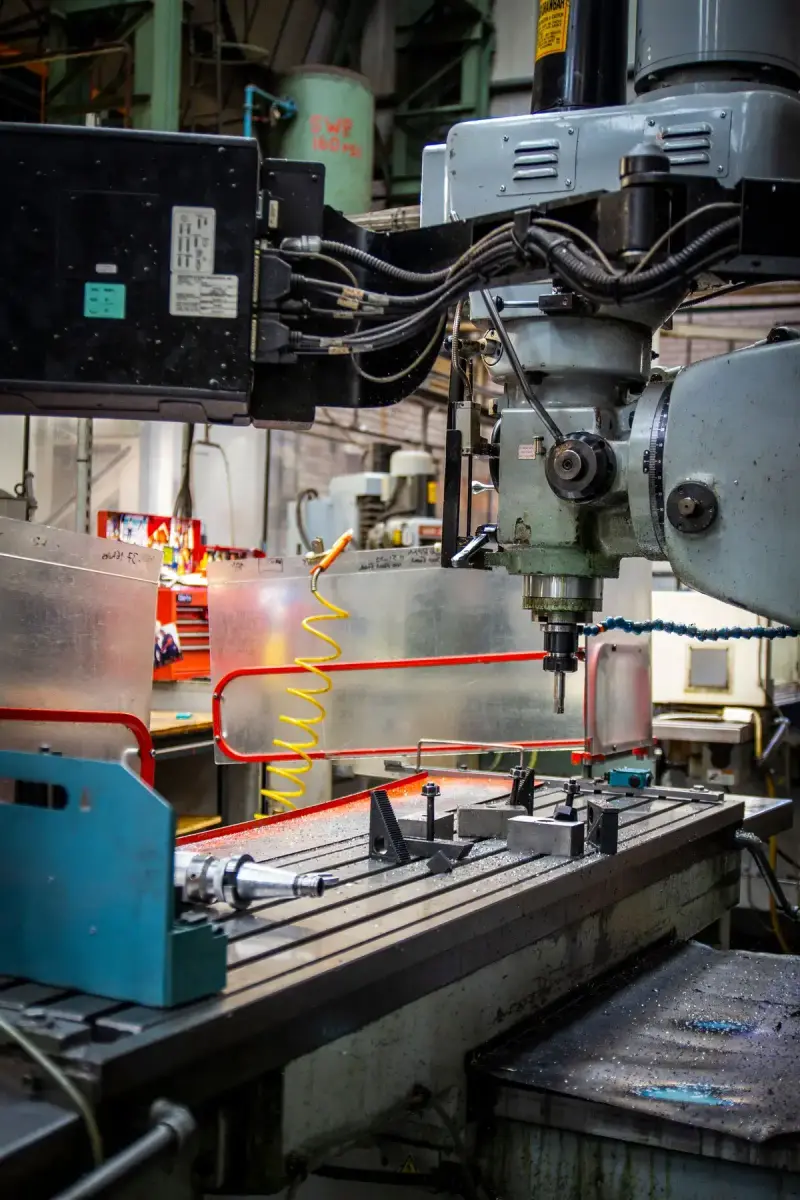 Industrial CNC lathe working on a metal part in a busy machine shop