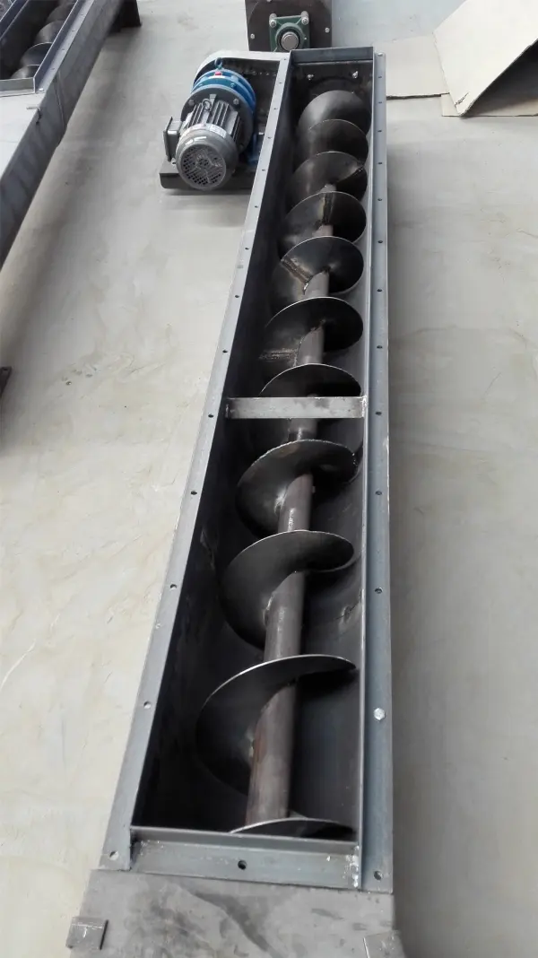 An exposed screw conveyor, shown lengthwise; bulk handling equipment reference.