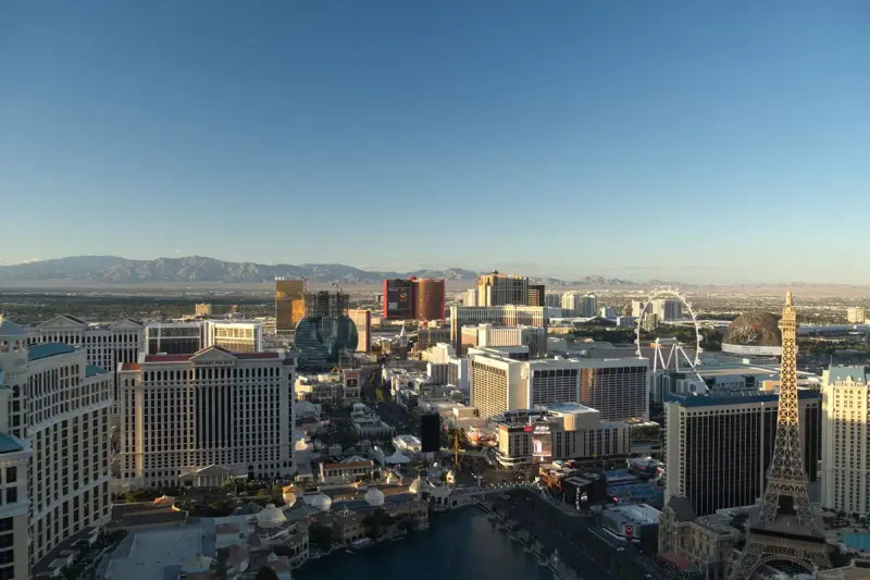 Aerial view of the Las Vegas skyline and resort towers at daybreak with mountains beyond