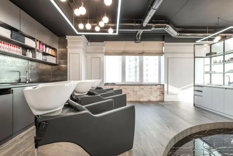Salon interior with styling chairs, backwash units and shelves of supplies