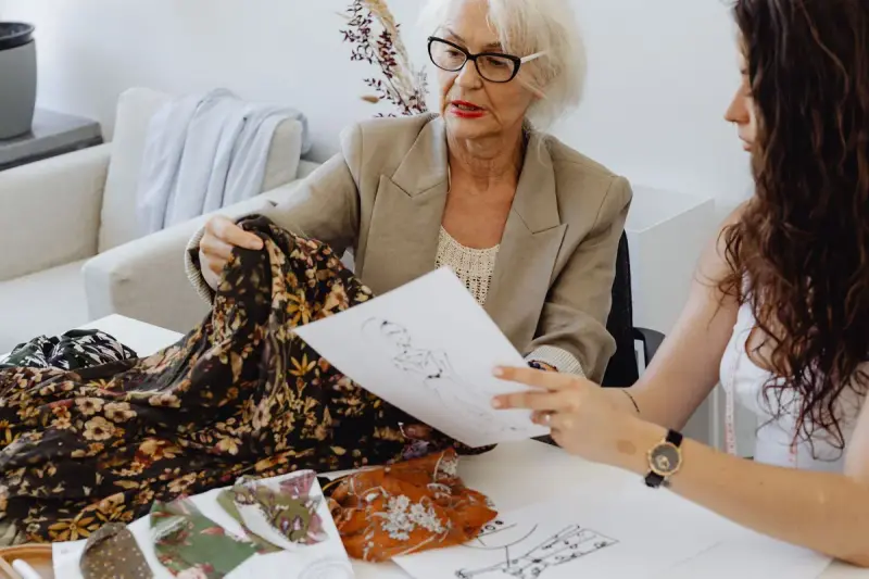 Two designers reviewing a printed fabric and sketches at a table