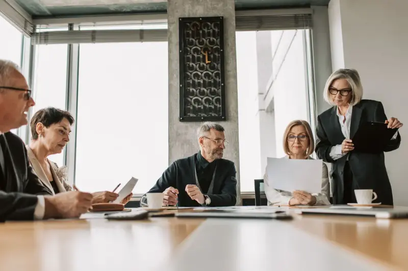 Professionals discussing documents in a modern meeting room