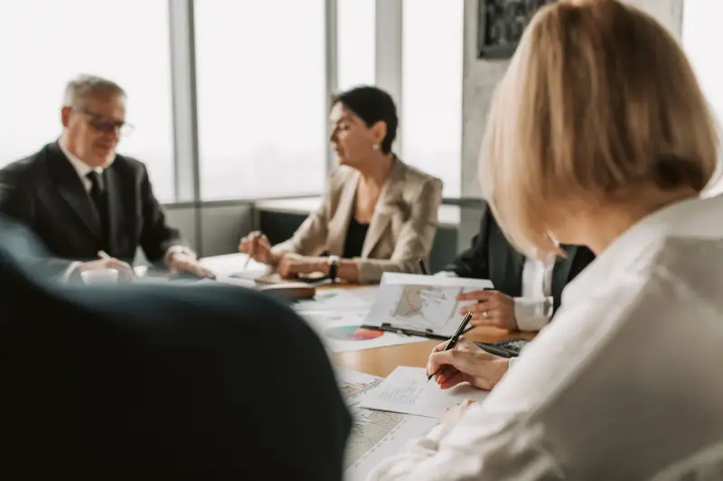 Colleagues discussing documents at an office meeting table
