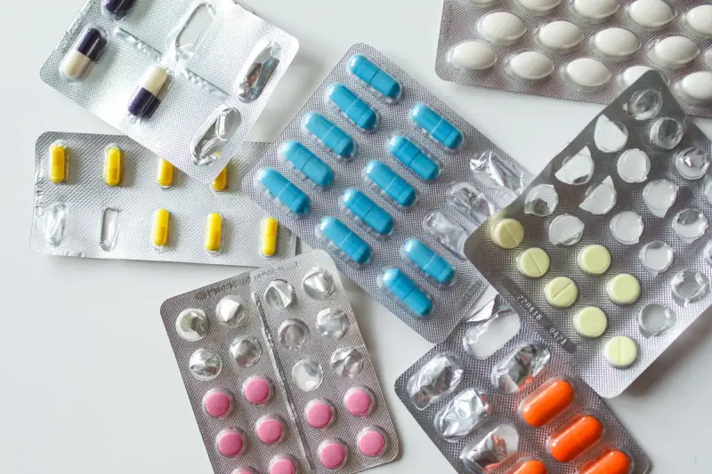 Assorted tablets and capsules in blister packs on a white surface