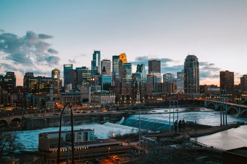 Minneapolis skyline with the river and a bridge at sunset