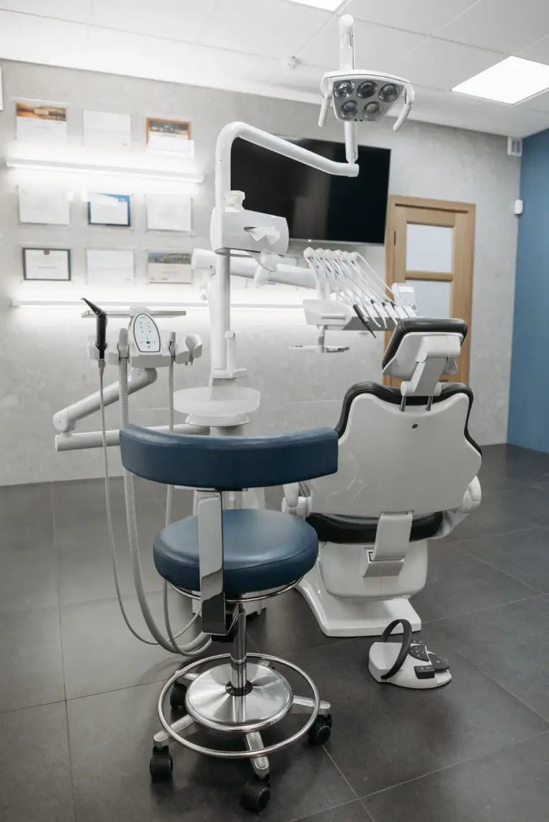 An empty dental office with a chair and modern equipment.