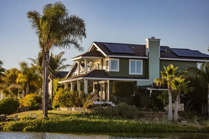 Modern home with rooftop solar panels surrounded by a lush garden