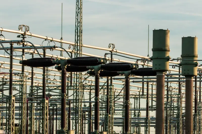 High-voltage substation equipment and insulators against a clear sky
