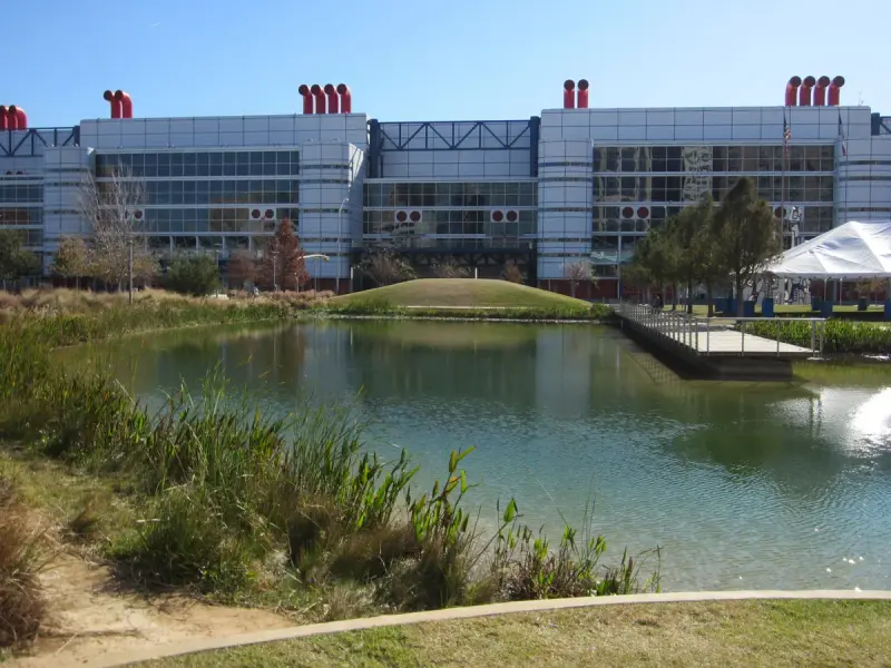 George R. Brown Convention Center facade with red stacks seen across the pond at Discovery Green, Houston