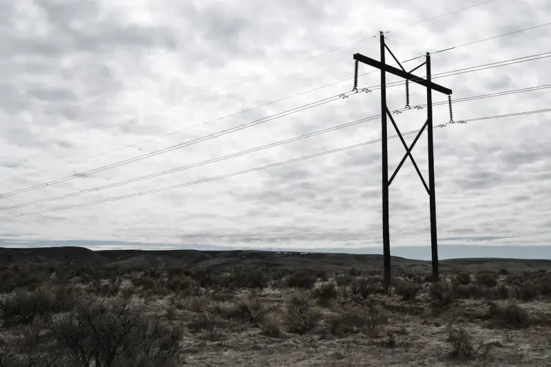 High-voltage power lines crossing a dramatic cloudy sky