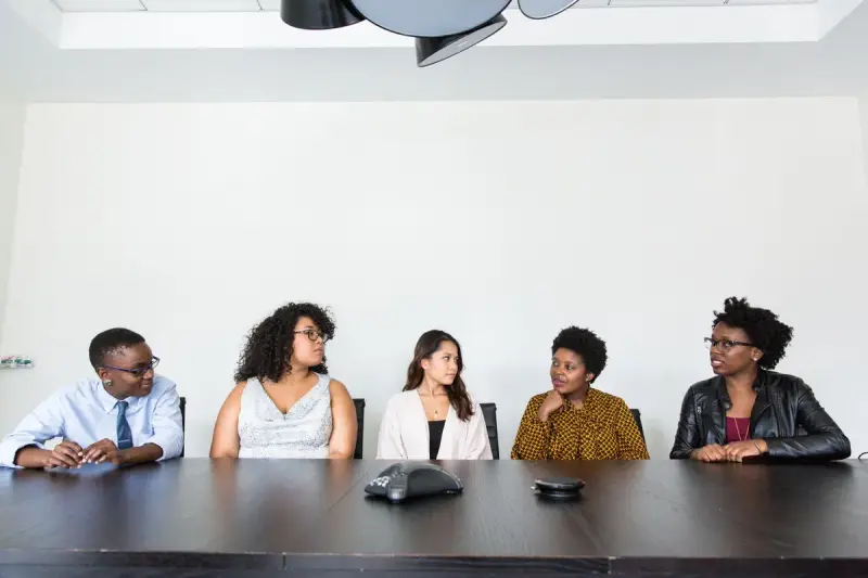 Group of professionals in conversation around a table in a modern office