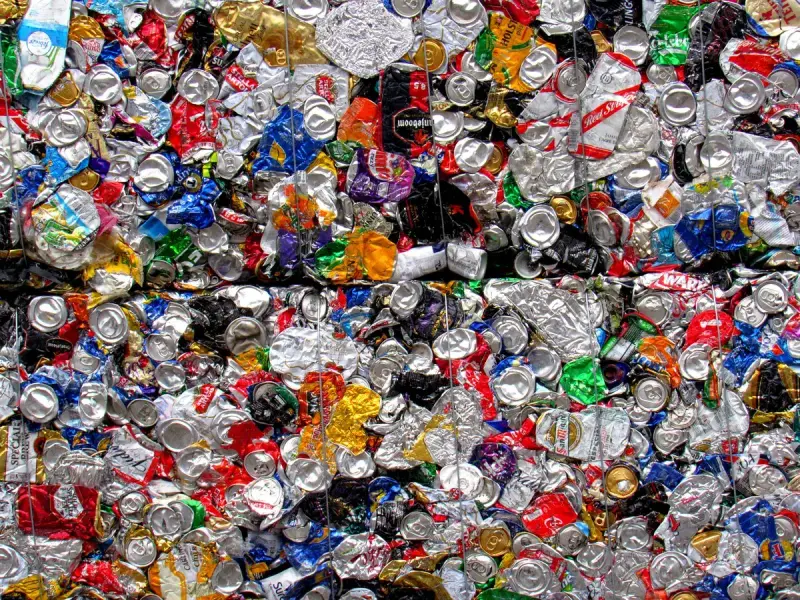 Close view of stacked bales of crushed aluminum drink cans held by baling wire