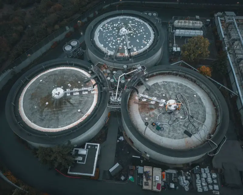 Aerial view of round covered treatment tanks at an industrial site