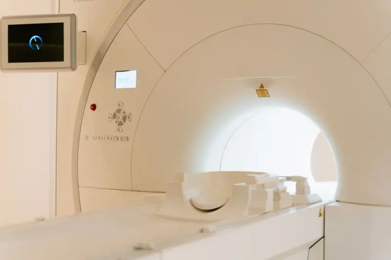 Close view of a lit scanner bore with a head coil resting on the table